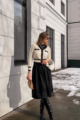 a lady in a white knit top and a black skirt